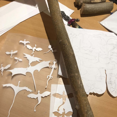 A presently uncarved staff on top of dragon tracings and stencils.