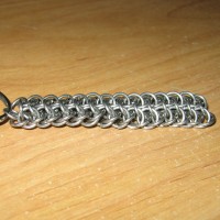 The grey chainmaille pattern, laying on a wooden desk