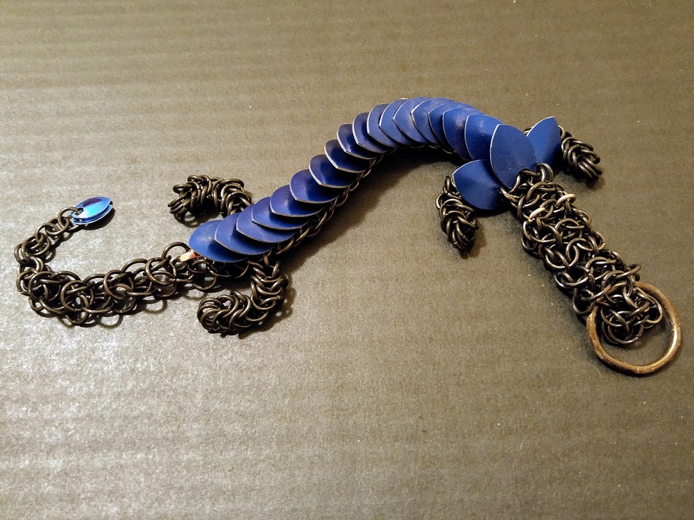 A blue dragon with black rings sitting on a black corrugated box.