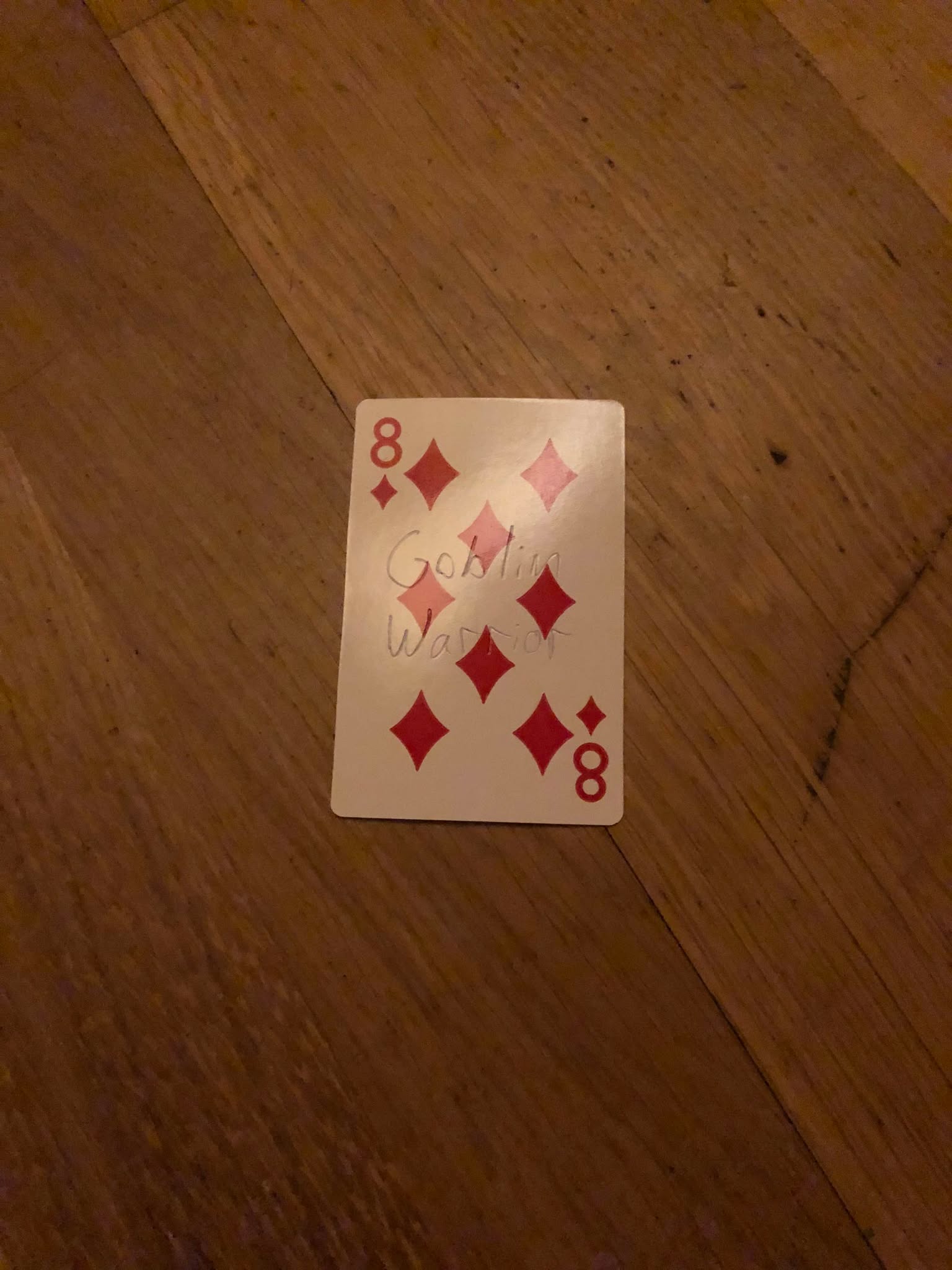 The eight of diamonds, thrown to the floor in front of the creature.