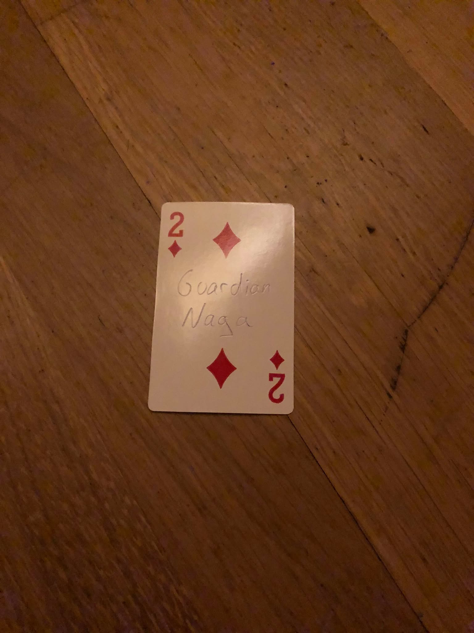 The two of diamonds, thrown to the floor in front of the creature.