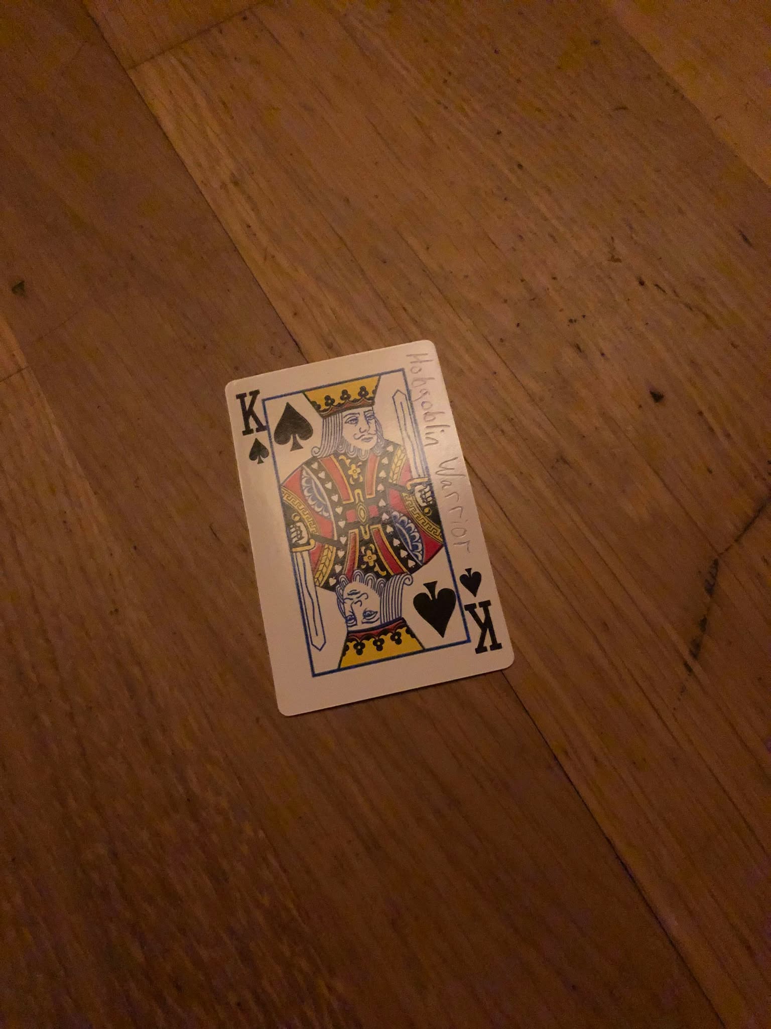 The king of spades, thrown to the floor in front of the creature.