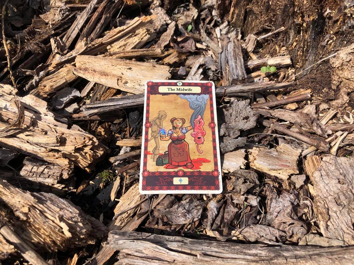 A birthed child, the card laying on the forest debris.