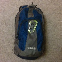 A blue and grey backpack on a grey carpet