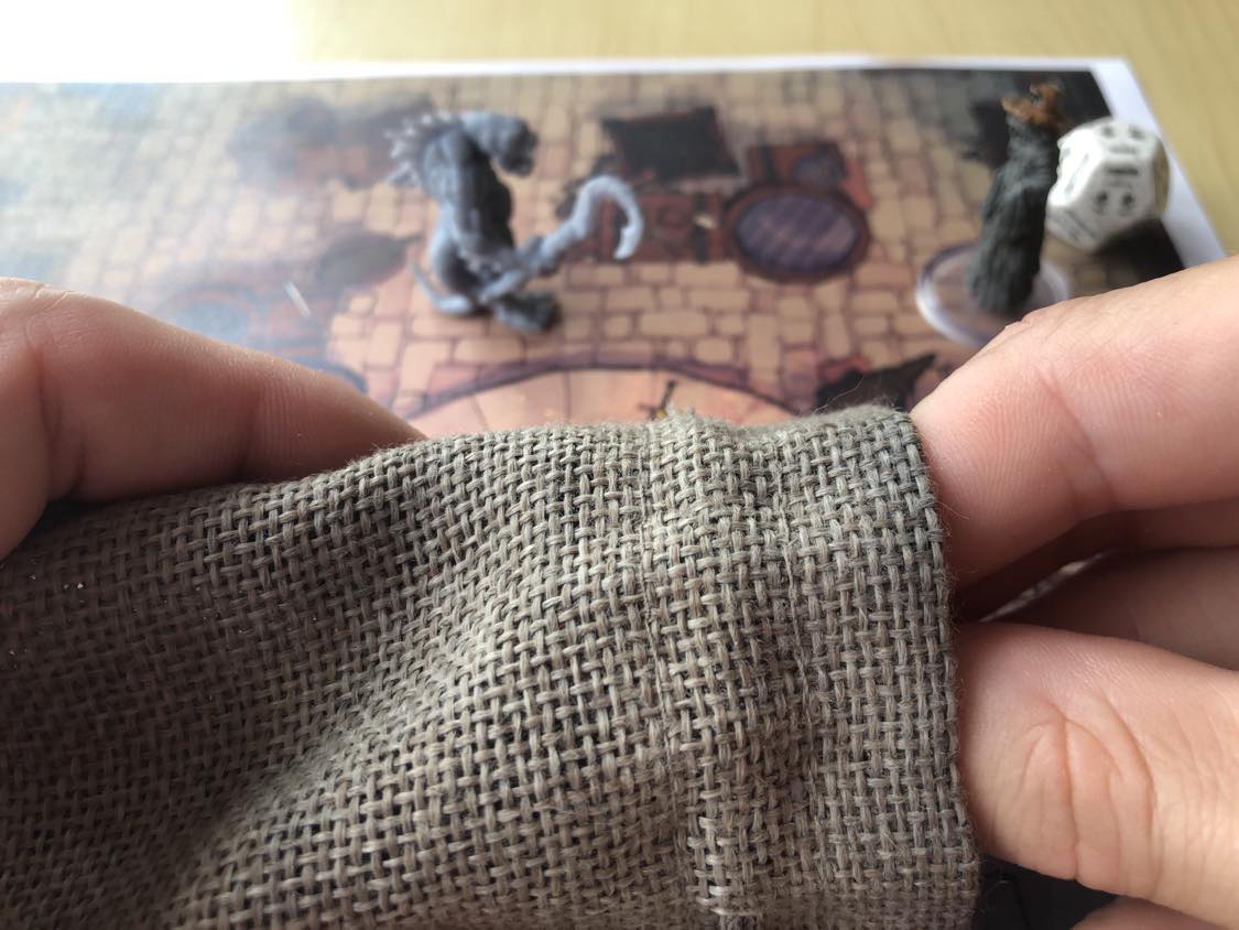 Reaching into the grey pouch, preparing to pull out a token to assist you against the attacker.