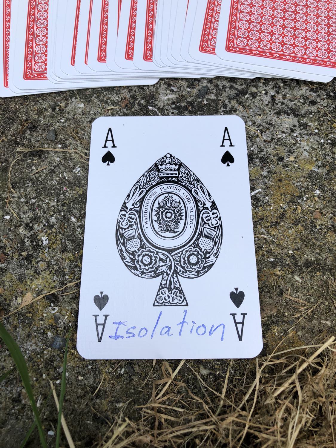 The ace of spades with the word Isolation written on it, laying on the bridge support.