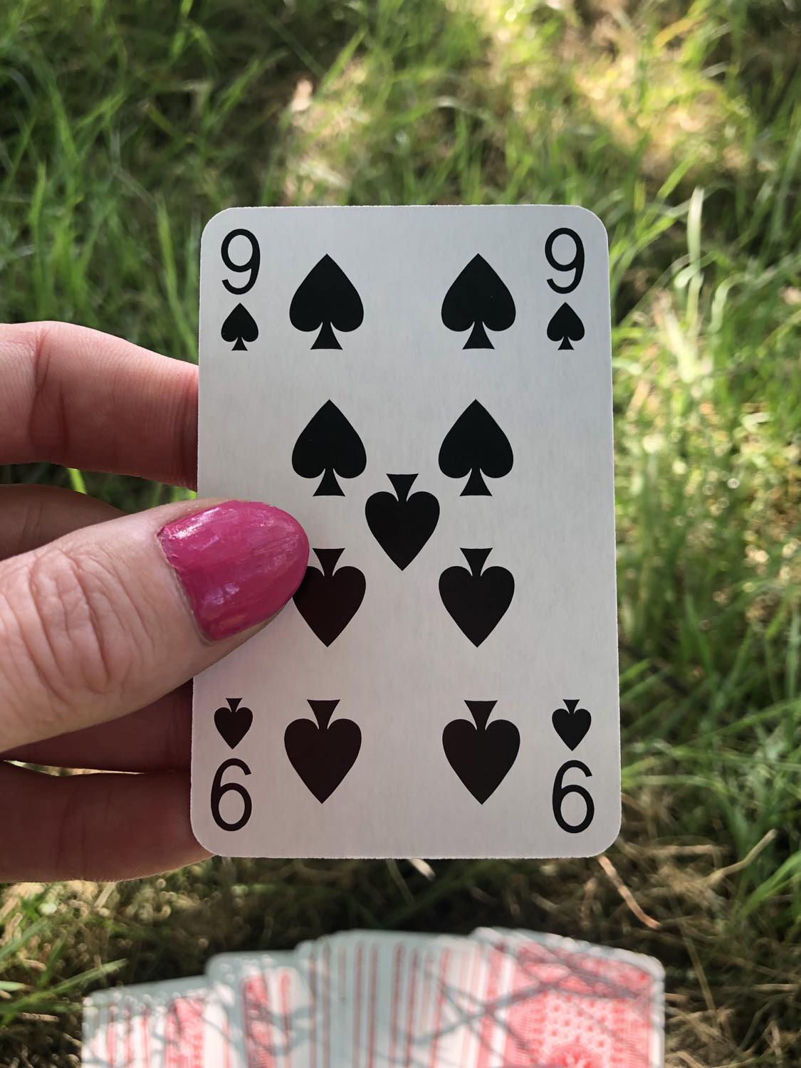 The nine of spades, held up from the drawn out cards.
