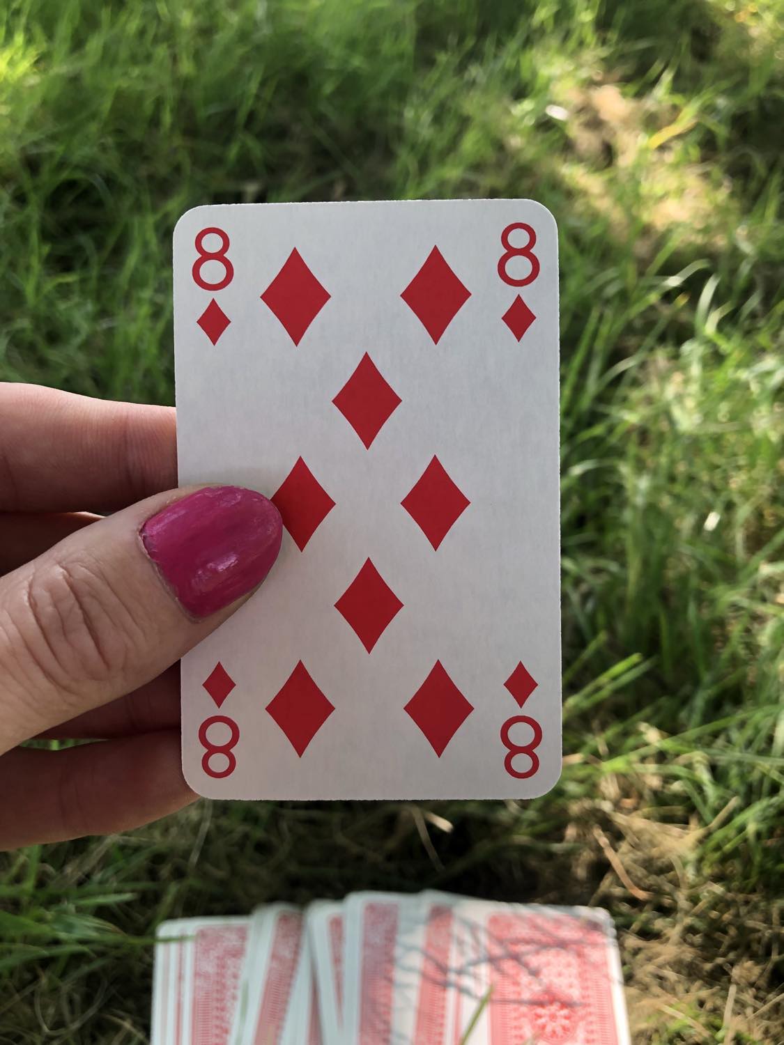 The eight of diamonds, held up from the drawn out cards.
