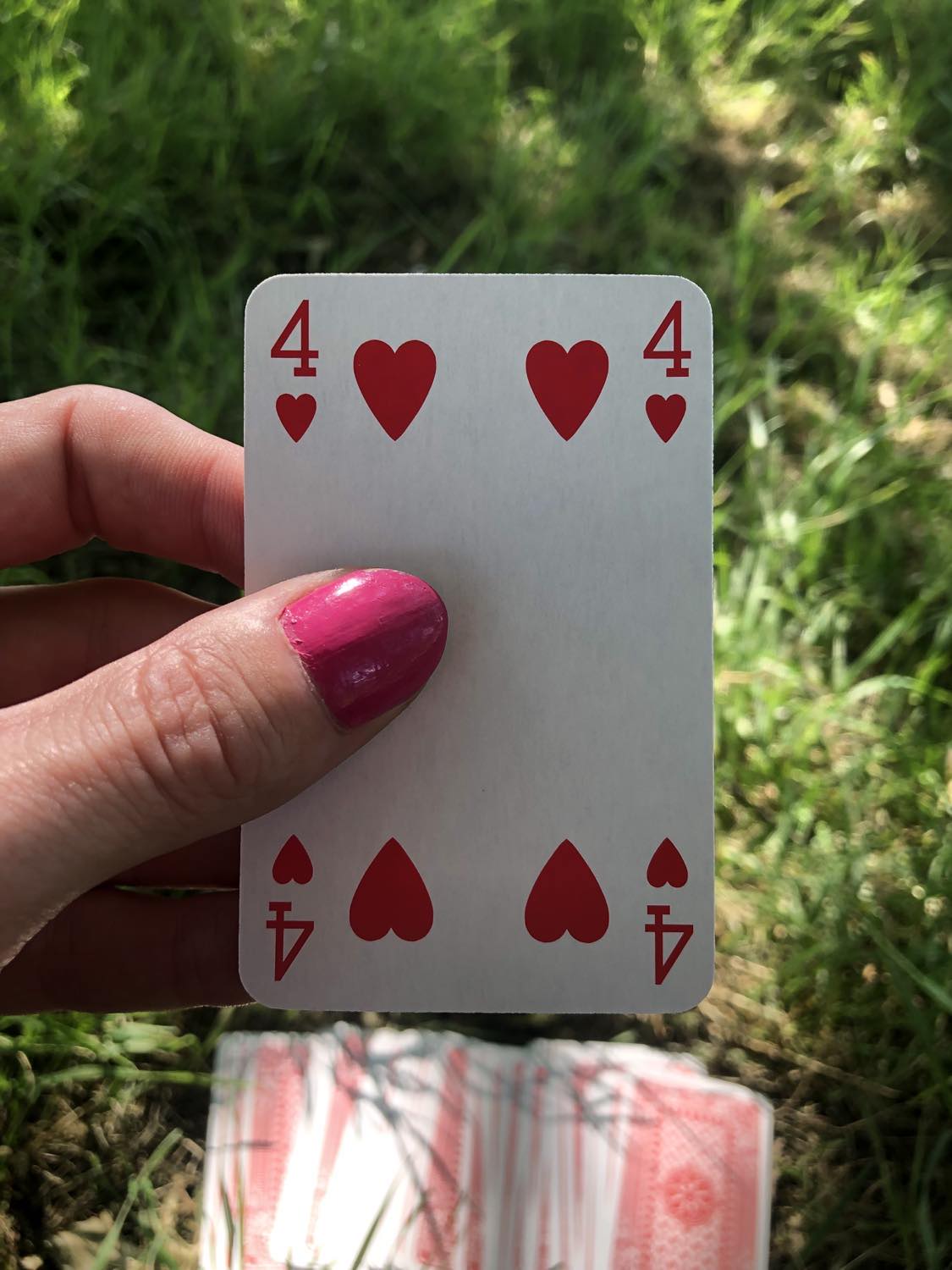 The four of hearts, held up from the drawn out cards.
