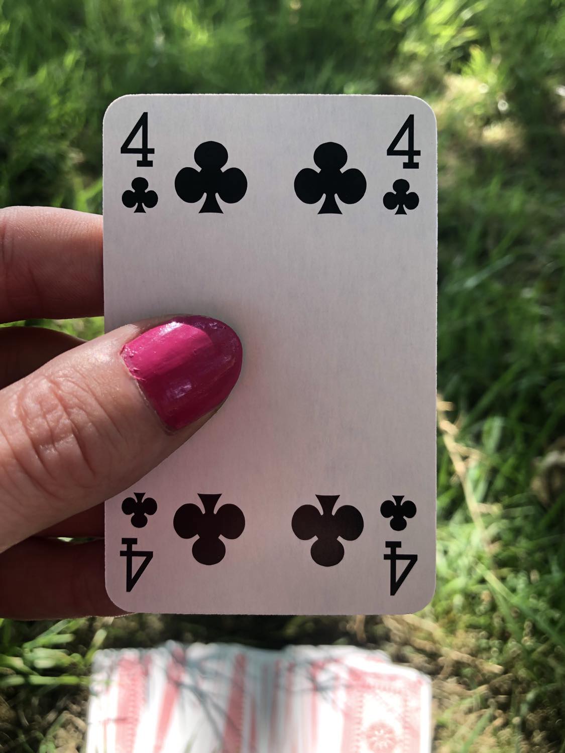 The four of clubs, held up from the drawn out cards.